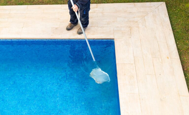 Pool cleaner in a net in his hands clean the pool. No face.