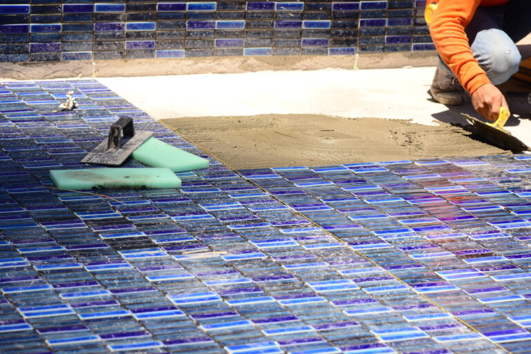 Blog 1 Workers are installing porcelain tiles in the pool.
